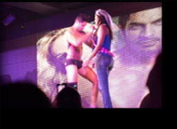 Male stripper dancing with the bride-to-be on stage at the strip show.